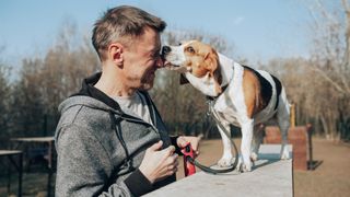 A man with a beagle licking his nose. Humans have two nostrils, but most people have one that is dominant.