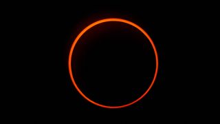 a large deep orange colored ring against a black background.