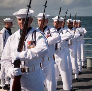 A US Navy firing squad fires three volleys in honor of Neil Armstrong during his burial at sea service aboard the USS Philippine Sea, Friday, Sept. 14, 2012, in the Atlantic Ocean.