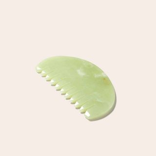 Hayo'u's Jade Body Comb gua sha against pink background