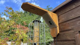 Green Feathers Bird Feeder Camera attached to an outdoors shed