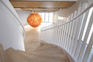 Entrance to the Port Ellen distillery with curved wooden stairway and amber art installation