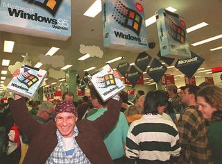 SYDNEY, AUSTRALIA - AUGUST 24: Mikol Furneaux(L) waves two packages of Windows 95 software in the first store in Australia to sell the product at midnight 24 August. Microsoft hopes to sell between 20 and 30 million copies of the software world wide by the end of 1995.