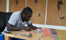 Portrait of Ghanaian artist Serge Attukwei Clottey working on a piece in his studio ahead of a show 'Beyond Skin' at Simchowitz Gallery Los Angeles