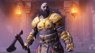 Kratos stands in gold armor at the entrance to a fire-lit temple