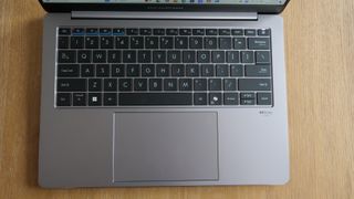 Top-down view of the Asus ExpertBook P5 (P5405) on a wooden table to show keyboard and touchpad