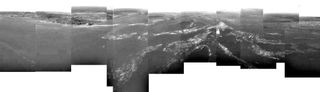 This first panorama of Titan released by ESA shows a full 360-degree view around the Huygens probe. The left-hand side shows a boundary between light and dark areas. The white streaks seen near this boundary could be ground 'fog', as they were not immediately visible from higher altitudes. Huygens drifted over a plateau (centre of image) and was heading towards its landing site in a dark area (right) during descent.