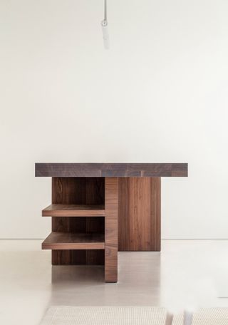 The side of a thick hard wooden kitchen top featuring 3 side shelves photographed against a cream background