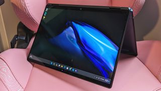 HP Spectre x360 14 2024 open in tent mode on a chair to show off flexible 2-in-1 design