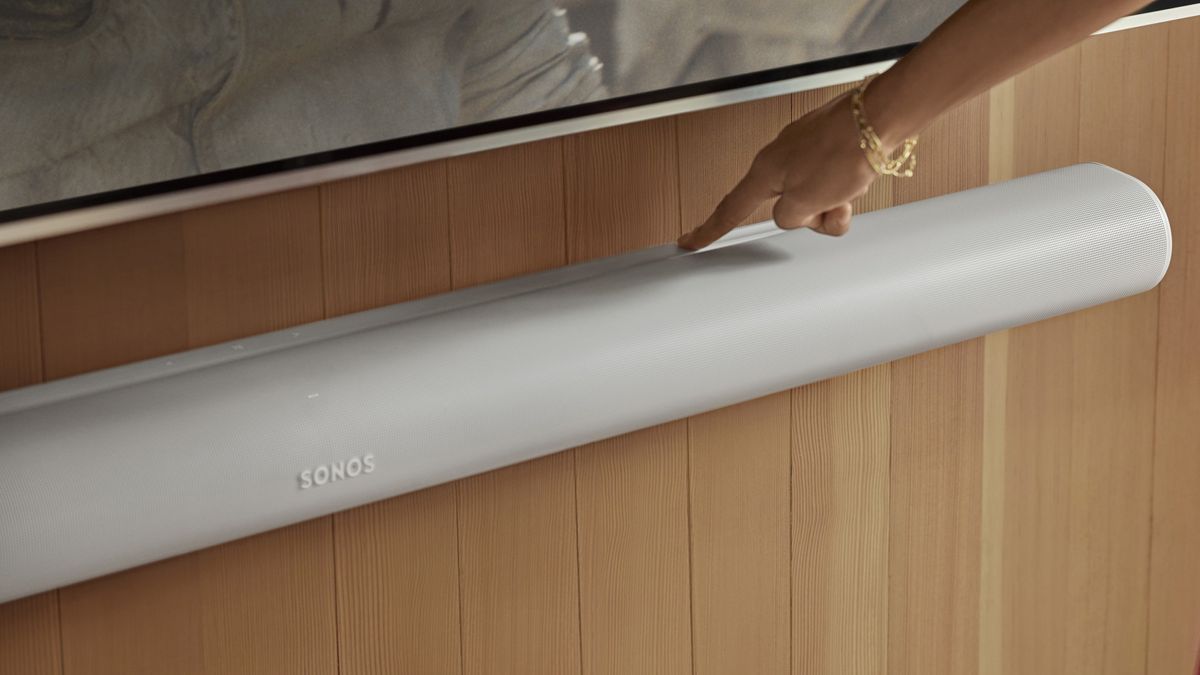 Sonos Arc Ultra in white with a woman&#039;s hand pressing the control