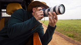 Man using one of the best cameras for wildlife photography in a vehicle