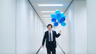 Adam Scott in Severance season 2 holding blue balloons down an ominous hallway