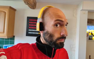 Man weating yellow Form 2 headphones looking at camera