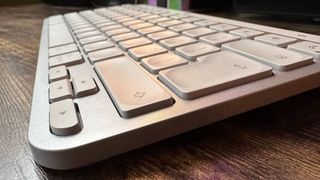 The Logitech MX Keys Mini for Mac keyboard on a wooden desk