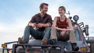 Glen Powell and Daisy Edgar-Jones sit on the hood of a truck in &quot;Twisters&quot;