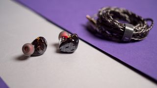 Fiio FA19 IEMs next to cable against colorful background