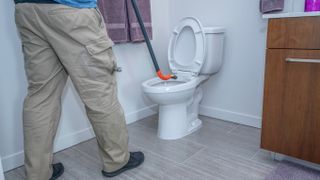 Man using a toilet snake