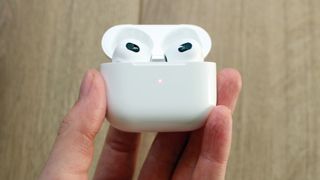 Una mano sujeta los AirPods de 3ª generación de Apple en su estuche de carga