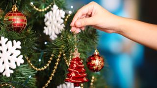 A Christmas tree being decorated with snowflakes, Christmas trees and baubles