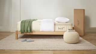 The Birch Luxe Natural Mattress placed on a wooden bed frame in a neutral color bedroom