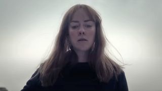 Jena Malone looks down at something off-camera in Consecration