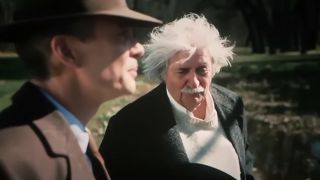 Cillian Murphy wearing a fedora as Robert Oppenheimer, talking to Tom Conti as Albert Einstein in Oppenheimer