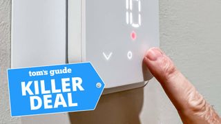 A photo of a person using the Amazon Smart Thermostat, with the &quot;Tom&#039;s Guide Killer Deal&quot; tag overlaid