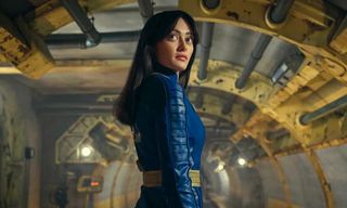 A woman dressed in blue standing in an underground vault