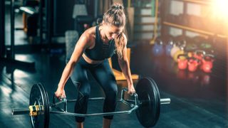 a photo of a woman doing a trap bar deadlift