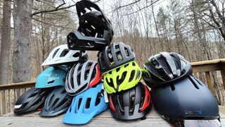 Colorful bike helmets stacked on a table.