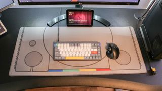 An overhead shot of a desk with a desk mat