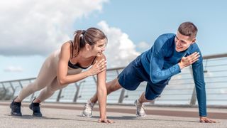 a photo of a man and woman performing plank shoulder taps