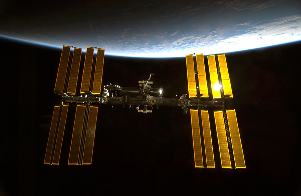 Sunlight glints off the International Space Station.