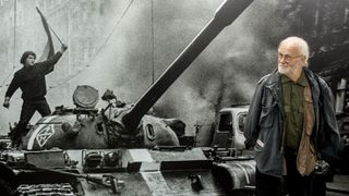 Czech photographer Josef Koudelka looks at one of the photographs in his exhibit "Invasion 68 Prague", organized by the French Institute and the Czech Centre in Bucharest, to commemorate the 45th anniversary of the Soviet invasion in Czechoslovakia, on October 17, 2013. The exhibition that presents the historical moments of Prague Spring in August 1968 will run until February 2, 2014. AFP PHOTO / ANDREI PUNGOVSCHI 