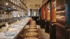 The bar at The Palomar London restaurant with velvet seats and a marble tabletop