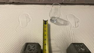 Puffy Cloud mattress motion isolation test featuring an empty glass, a 25lb weight, and a tape measure