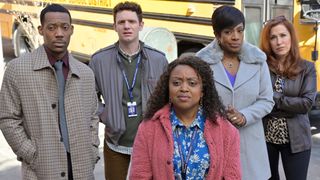 The cast of Abbott Elementary outside, looking up at a sign