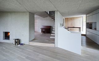 fire place in an open space and a piano next to the staircase