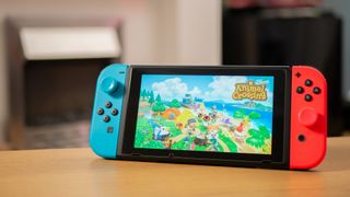 Nintendo Switch propped up on desk with Animal Crossing New Horizons image on screen.