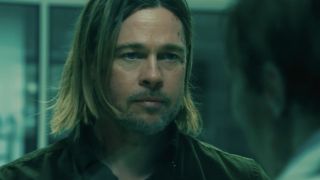 Brad Pitt stares at a zombie through a glass door in World War Z.