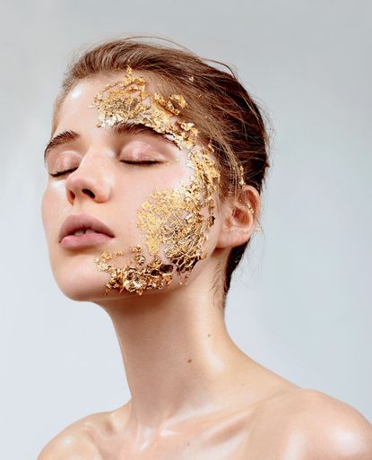 A woman with gold foil on the side her face