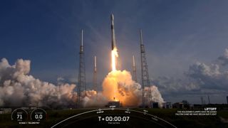 White and black rocket launching into a blue sky with white clouds