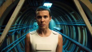 Millie Bobby Brown as Eleven, wearing her white vest 