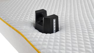 A 25kg weight placed on the edge of the Eve Premium Hybrid Mattress during testing to gauge the edge support