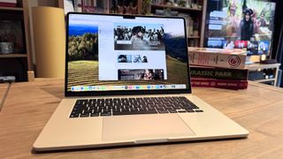 The 2024 MacBook Air M3 on a wooden table in front of a bookshelf.