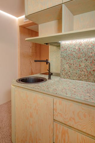 A wooden kitchen with speckled sink