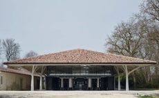 View of the Château Margaux extension - a structure with glass windows and metal columns covered by a large roof with its own support