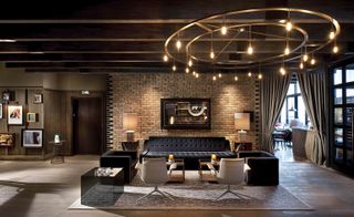 Large black leather sofas with a large circular ceiling light