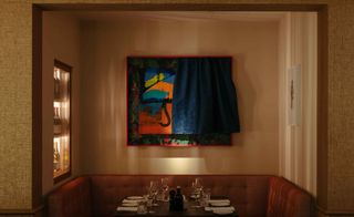 Ameron dining area with banquette seating, peach walls and colorful art