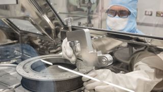 NASA’s OSIRIS-REx curation engineer, Neftali Hernandez, fixes one of the tools made to remove the two final fasteners to the capsule.